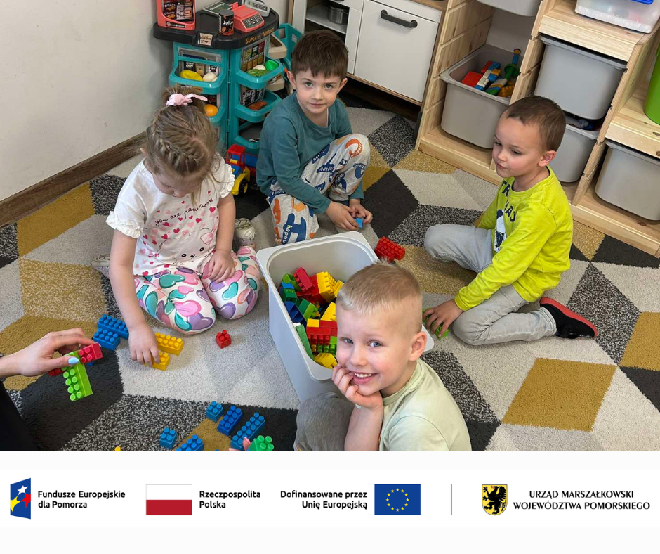  Dzieci w przedszkolu uczestniczące w zajęciach STEAM – siedzą na dywanie, eksperymentują z kolorowymi klockami i narzędziami edukacyjnymi. Na ścianie widać plansze edukacyjne. Uśmiechnięte twarze dzieci pokazują zaangażowanie i radość z nauki przez zabawę.Pasek logotypów: Fundusze Europejskie dla Pomorza, Rzeczpospolita Polska, dofinansowano przez Unię Europejską, Urząd Marszałkowski Województwa Pomorskiego